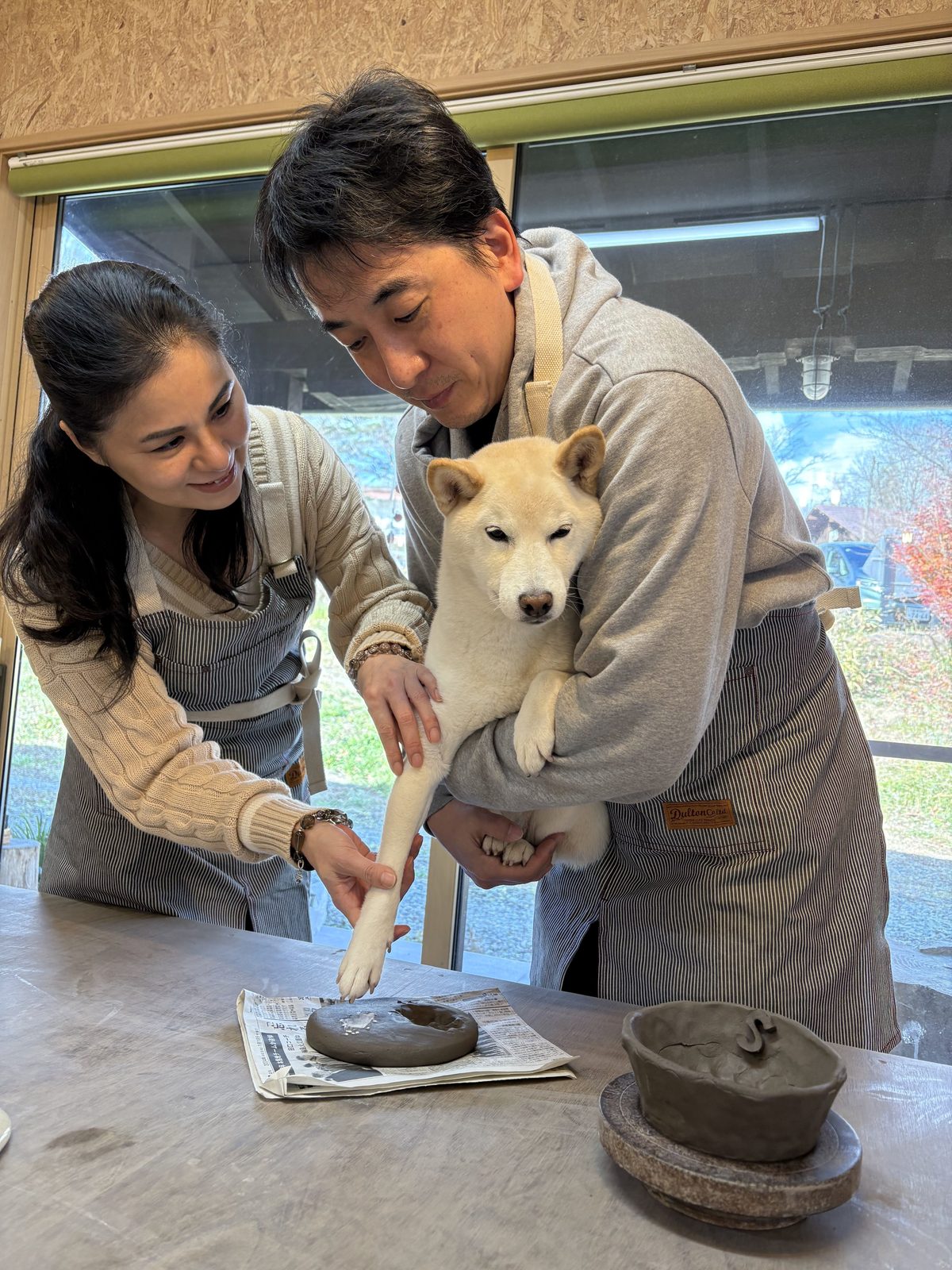 愛犬の前足を粘土に押しあてて、足跡をつけているところ