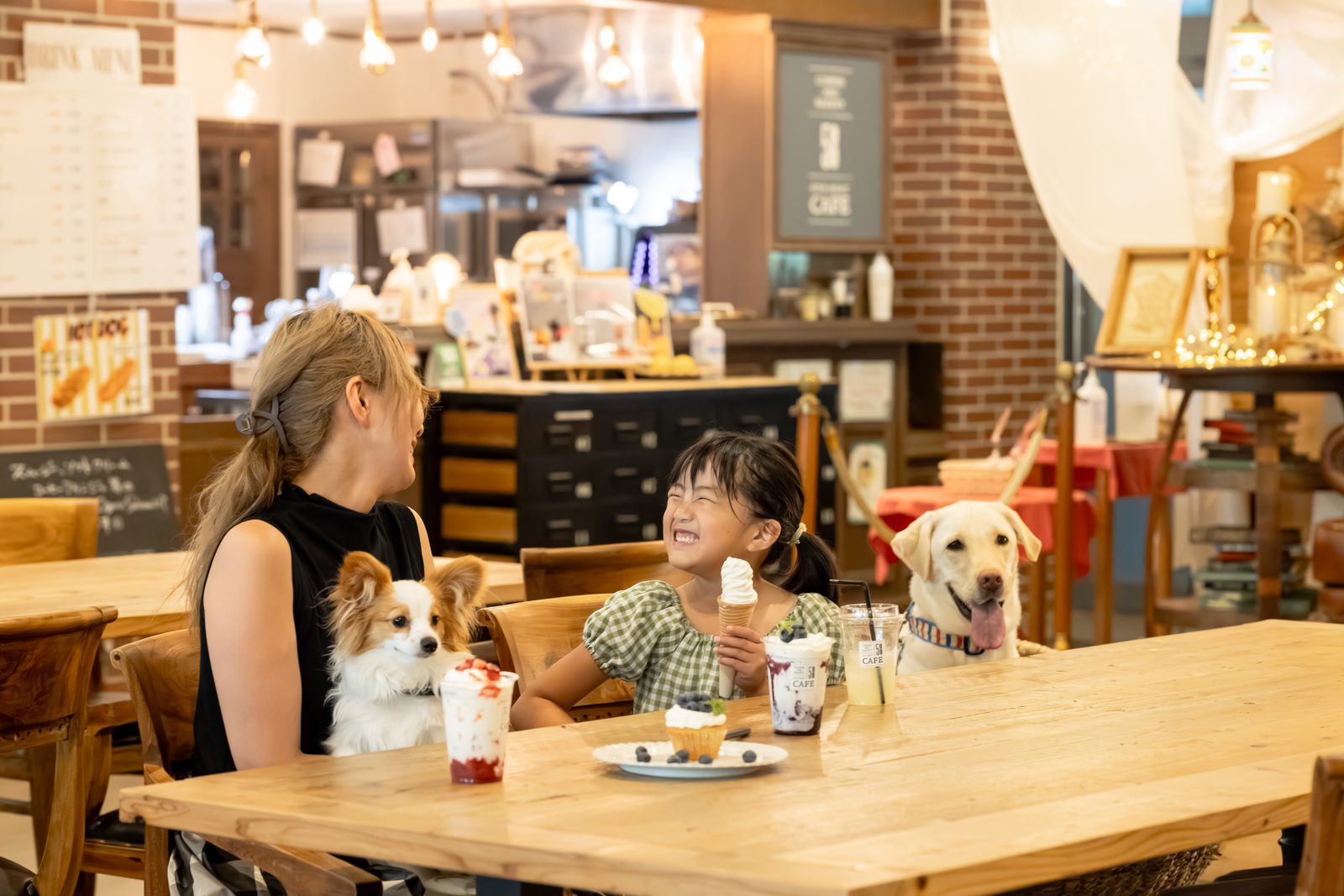 愛犬と一緒にテーブルにつく、カフェの店内