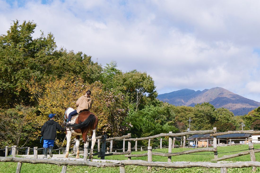 那須連山を背に乗馬を楽しむ親子